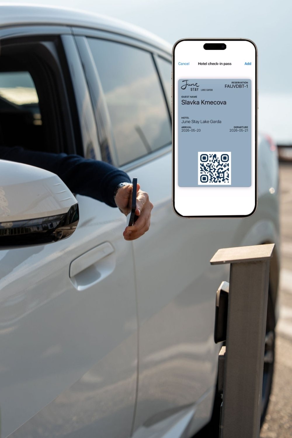 A guest reaching from a car window holding a phone, with a June Stay Lake Garda hotel check-in pass and QR code shown on screen ready to add to the wallet