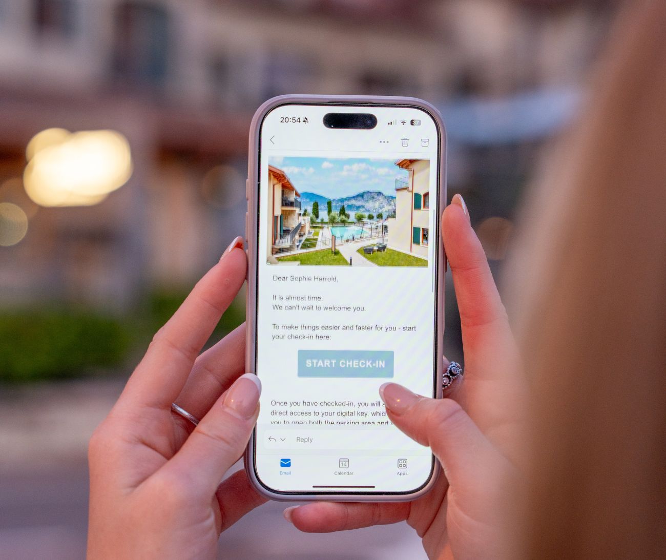 A guest reading the pre-arrival email on their phone — a welcome note with a START CHECK-IN button