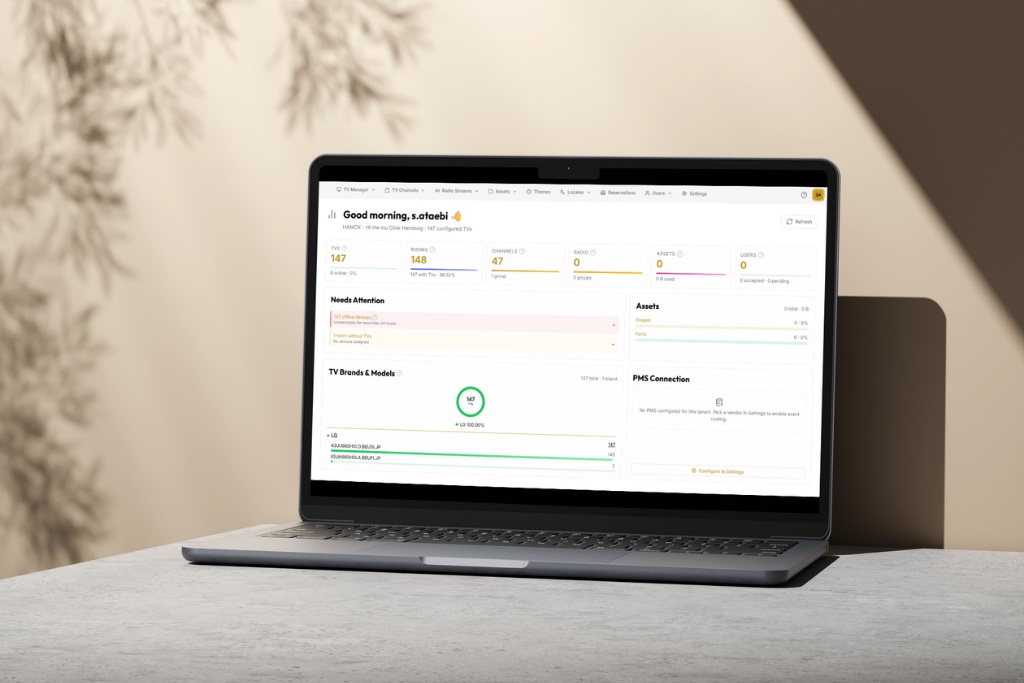 The cloud TV-management console open on a laptop, showing configured TVs, channels and TV brand models across a property