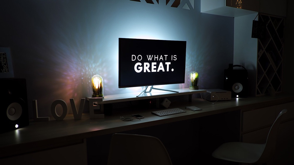 A 'Do what is great' message displayed on a TV in a softly lit room