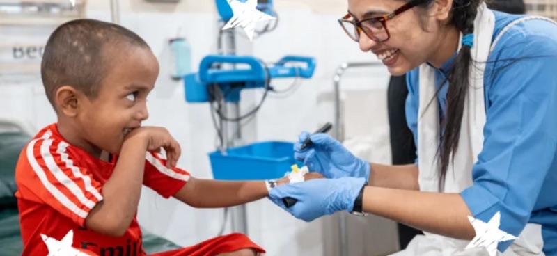 A nurse and a smiling child during care supported by Médecins Sans Frontières