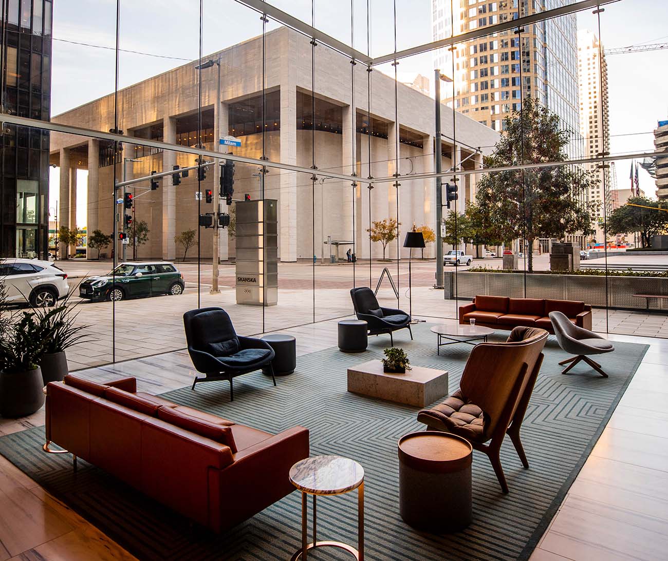 A modern hotel lobby lounge behind a floor-to-ceiling glass facade